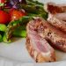 Close-up of grilled steak slices with asparagus and cherry tomatoes, perfect for a healthy meal.